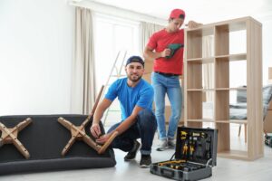 Movers disassembling couch and bookshelf 