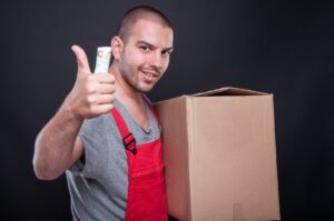 Mover holding a box in one hand and giving a thumbs up with cash in his other hand
